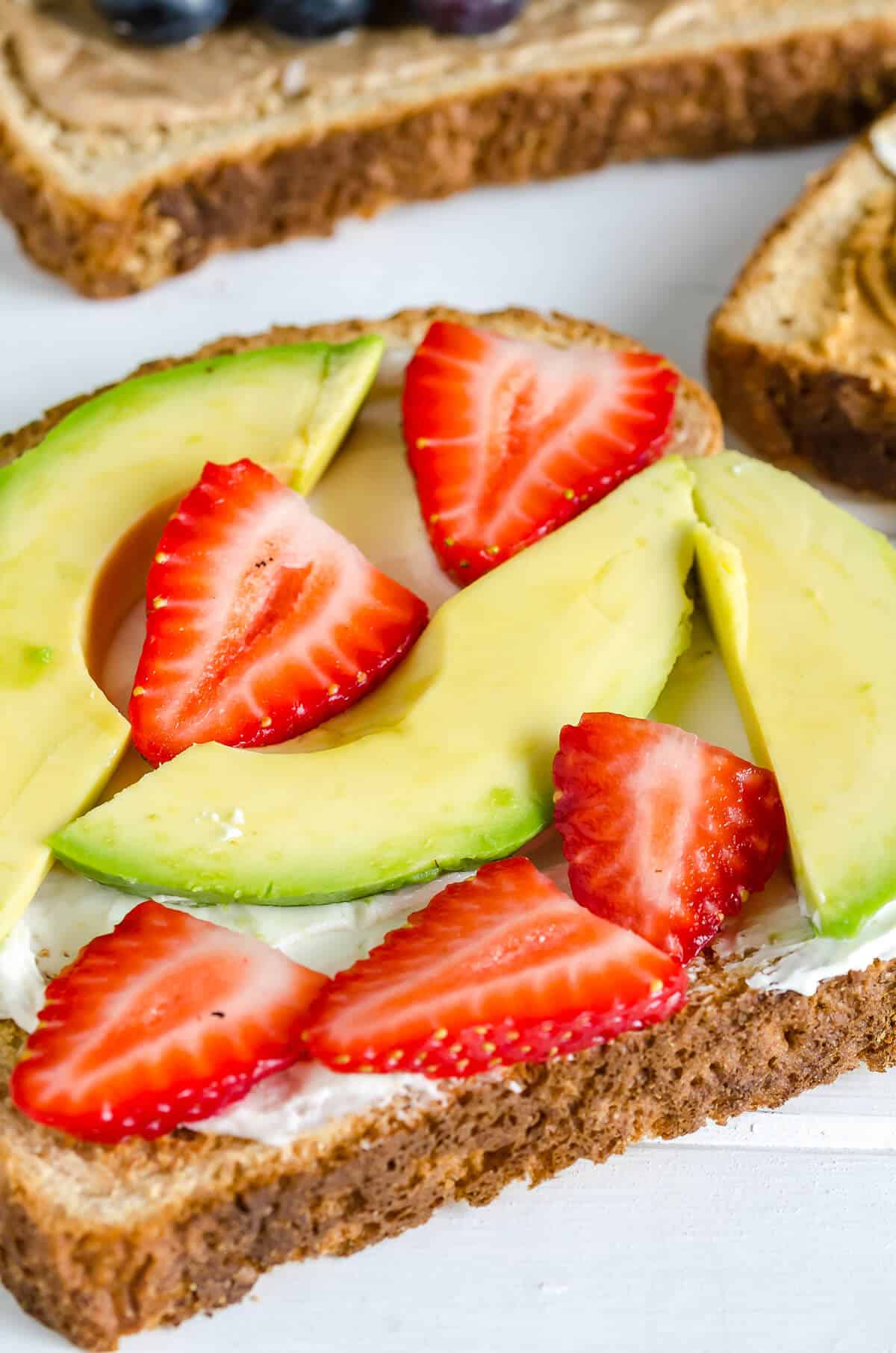Strawberry Avocado Toast, whole grain toast, cream cheese, sliced avocado and sliced strawberries