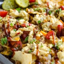 pan of bbq bacon cheeseburger nachos topped with cole slaw and barbecue sauce drizzle.