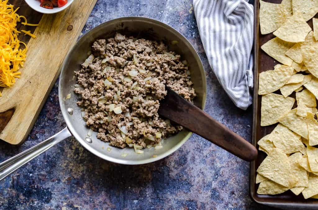 skillet of ground turkey and onions for bbq bacon cheeseburger nachos