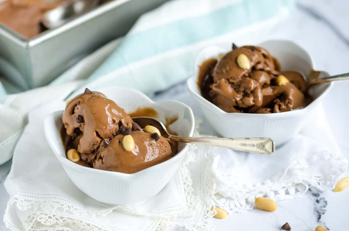 two white bowls filled with 4 ingredient chocolate peanut butter banana ice cream.