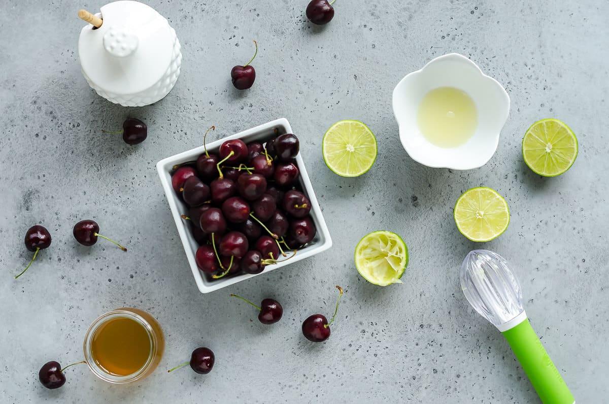 ingredients for cherry cooler. quart of sweet cherries, limes, lime juice and simple syrup made with honey