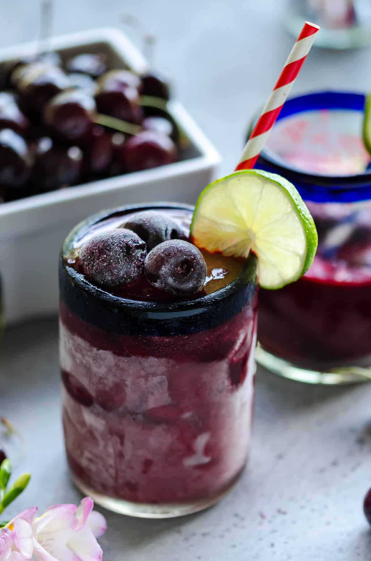2 glasses of sweet cherry coolers next to a quart of sweet cherries