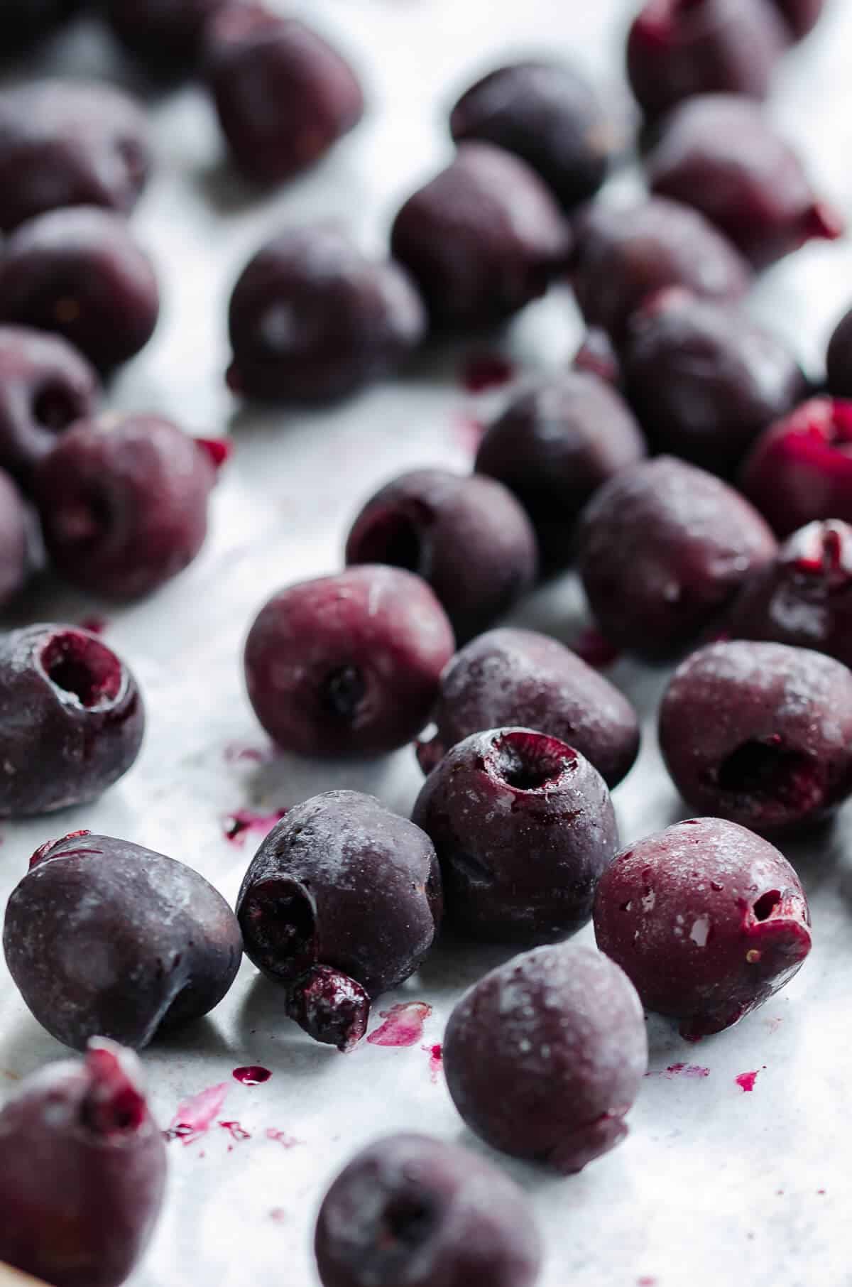frosty frozen cherries spread out on a sheet pan