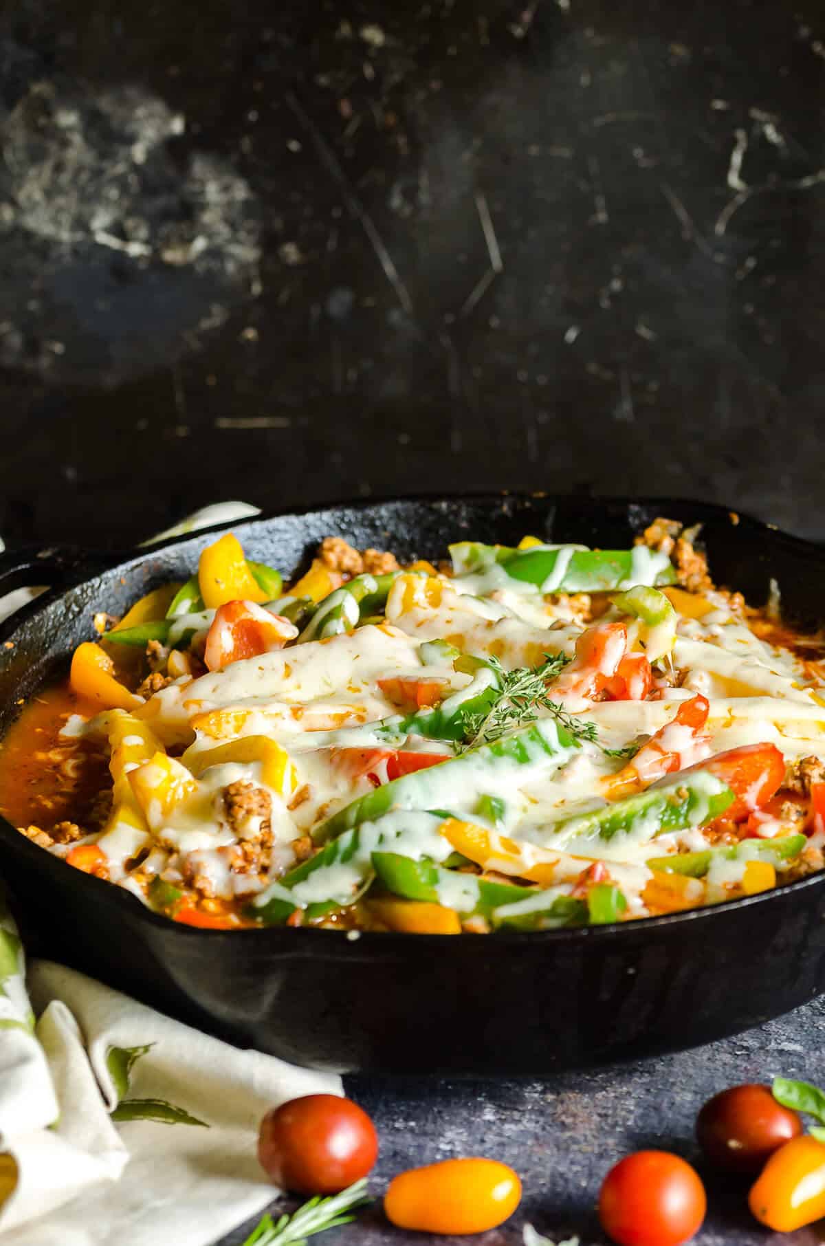 cast iron skillet with ground turkey, cauli rice, colored bell peppers and melted cheese