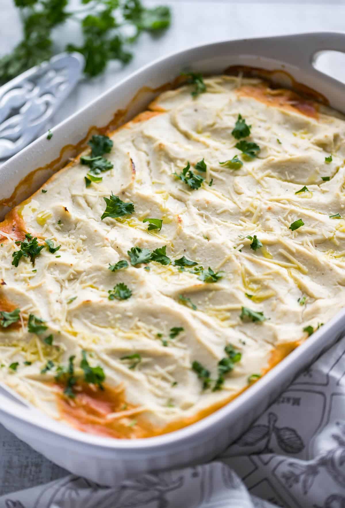 cottage pie with cauli mash in a white 9x13 dish garnished with parmesan cheese and parsley