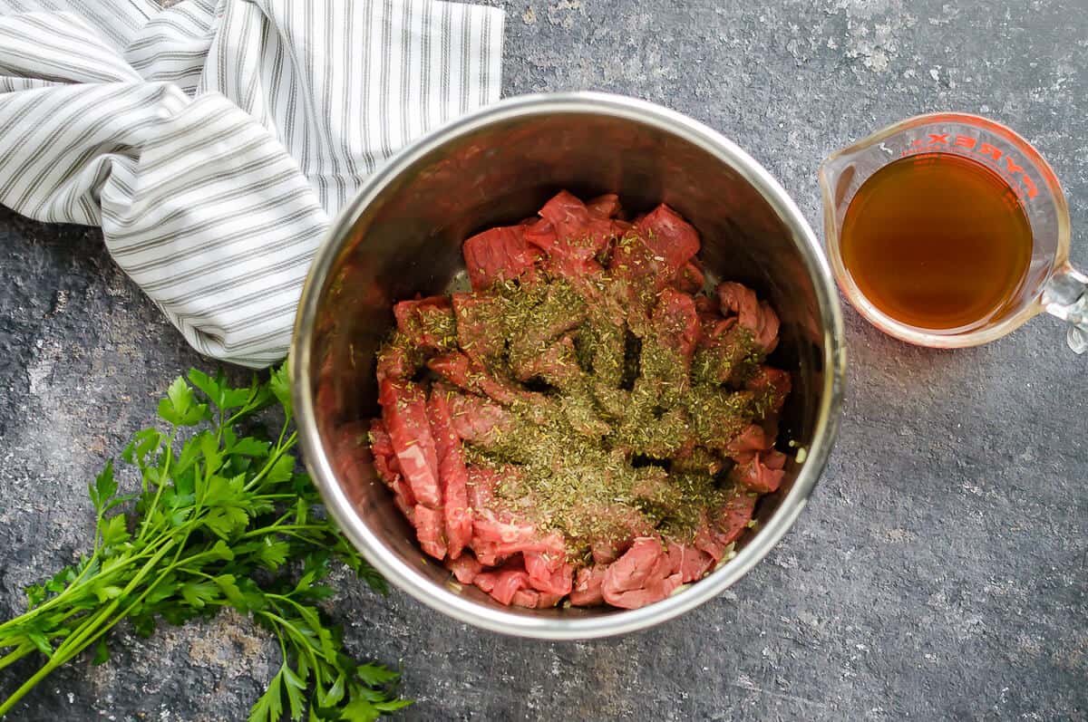 thinly sliced steak with seasonings in the instant pot