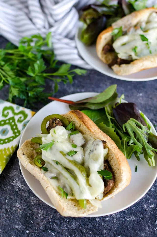 homemade philly cheesesteak on a bun with a side salad