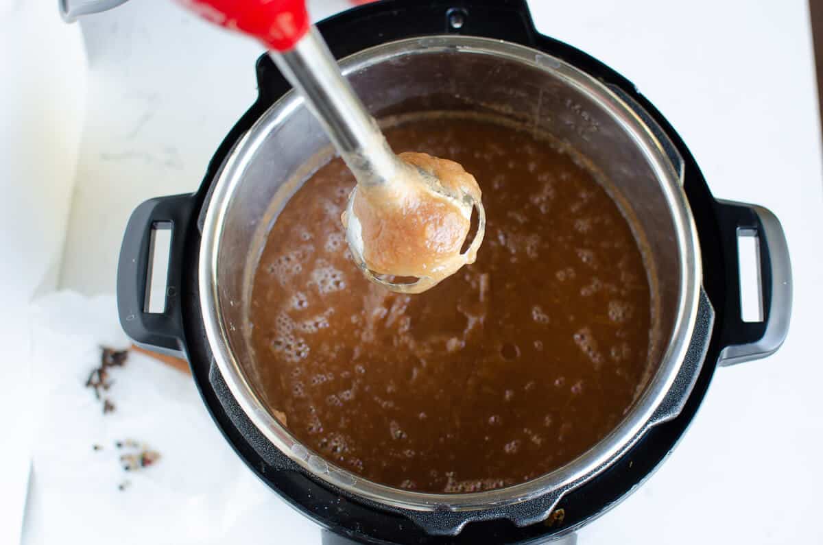 cooked apple butter in the instant pot with an immersion blender