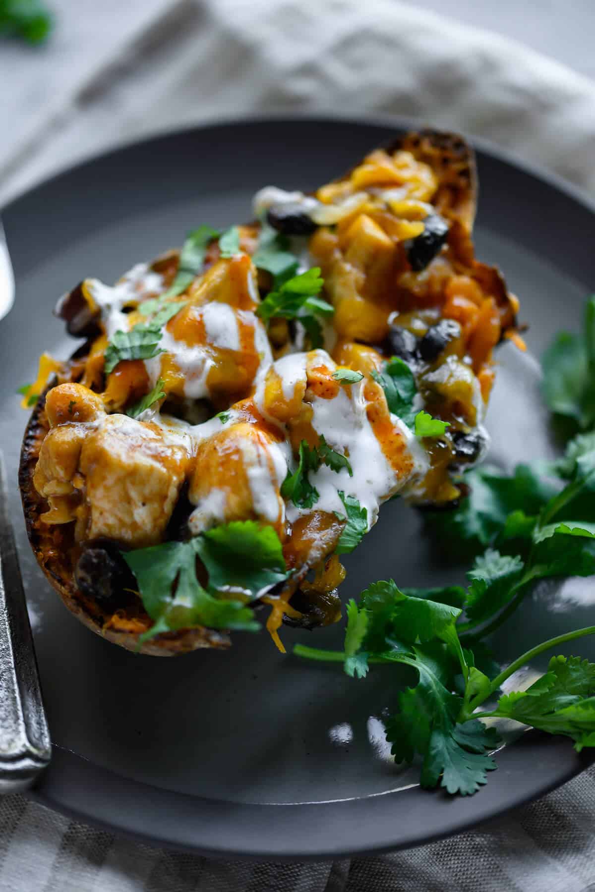 enchilada stuffed sweet potato on a plate garnished with cilantro