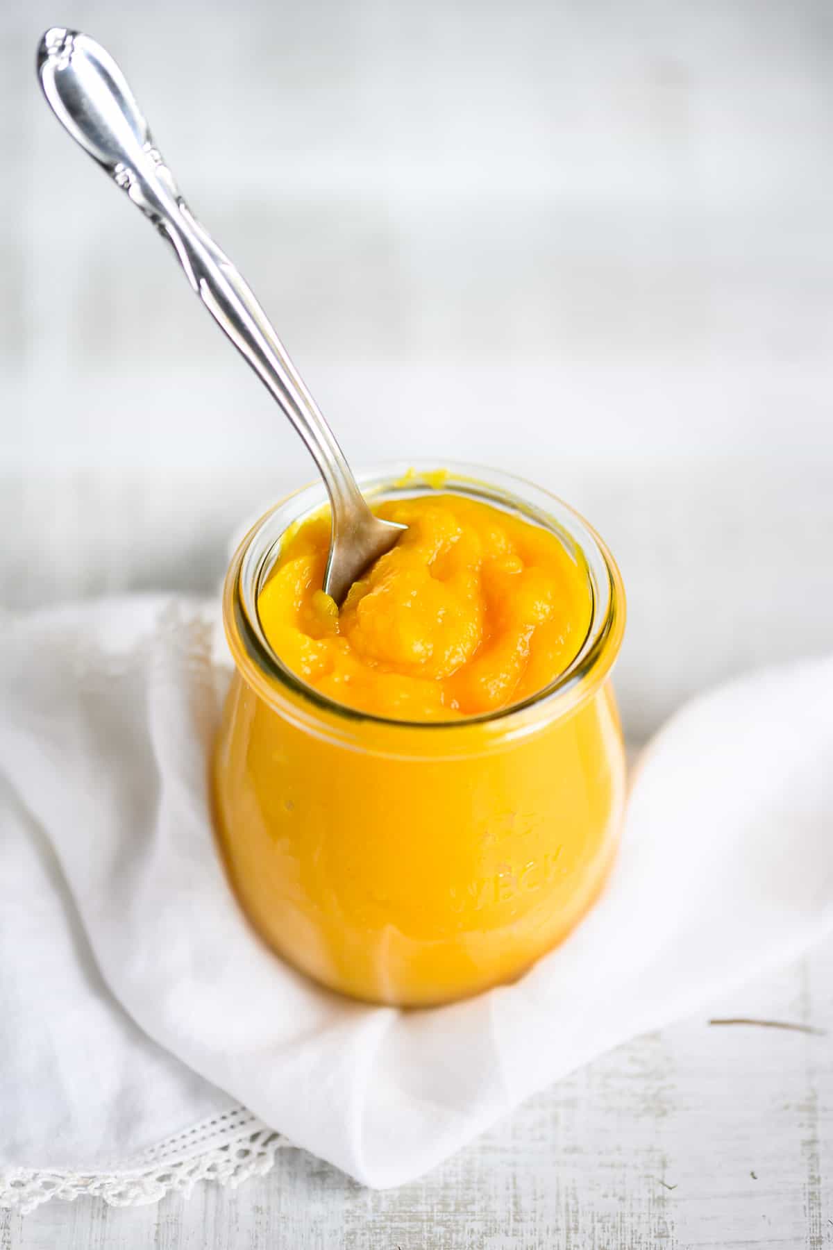 fresh pumpkin puree in a jar with a spoon sticking out