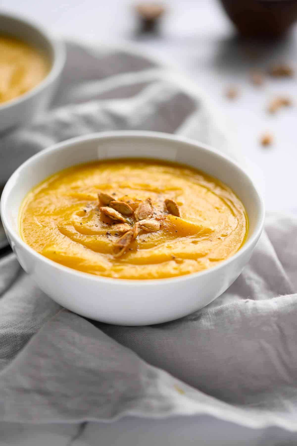 bowl of butternut squash soup garnished with squash seeds