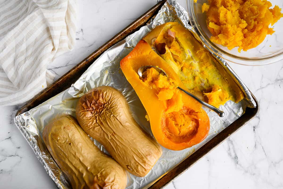 roasted butternut squash with flesh being scooped out