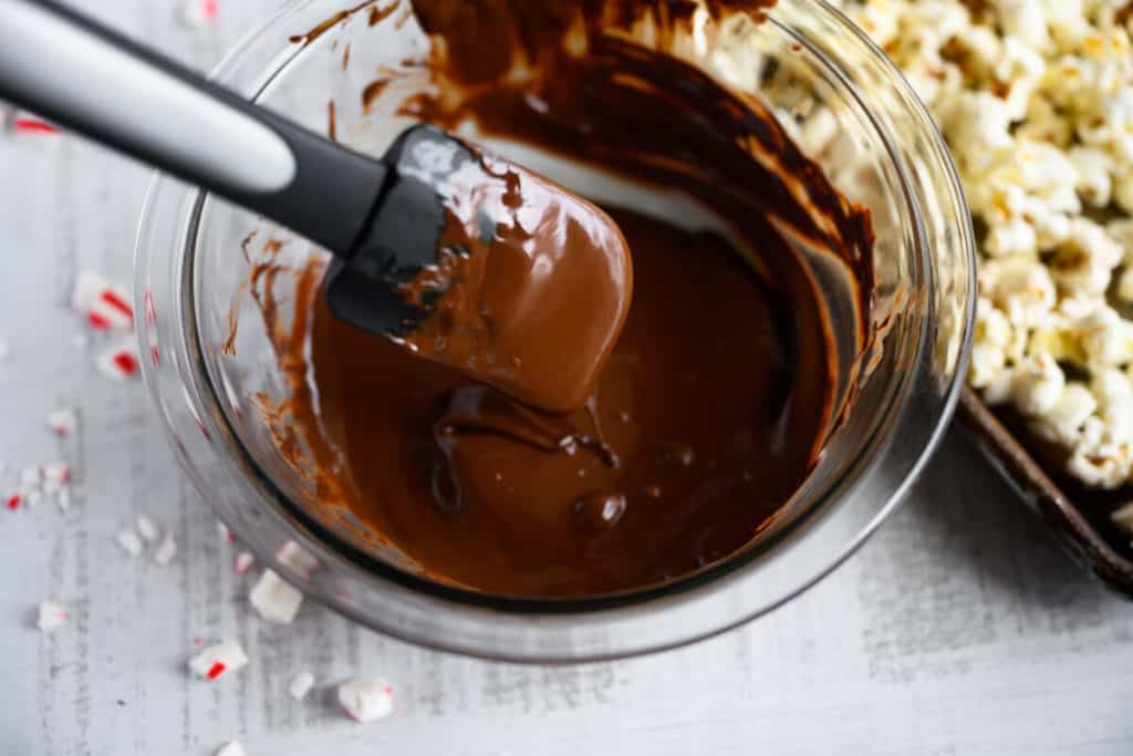 melted chocolate in a bowl next to popcorn