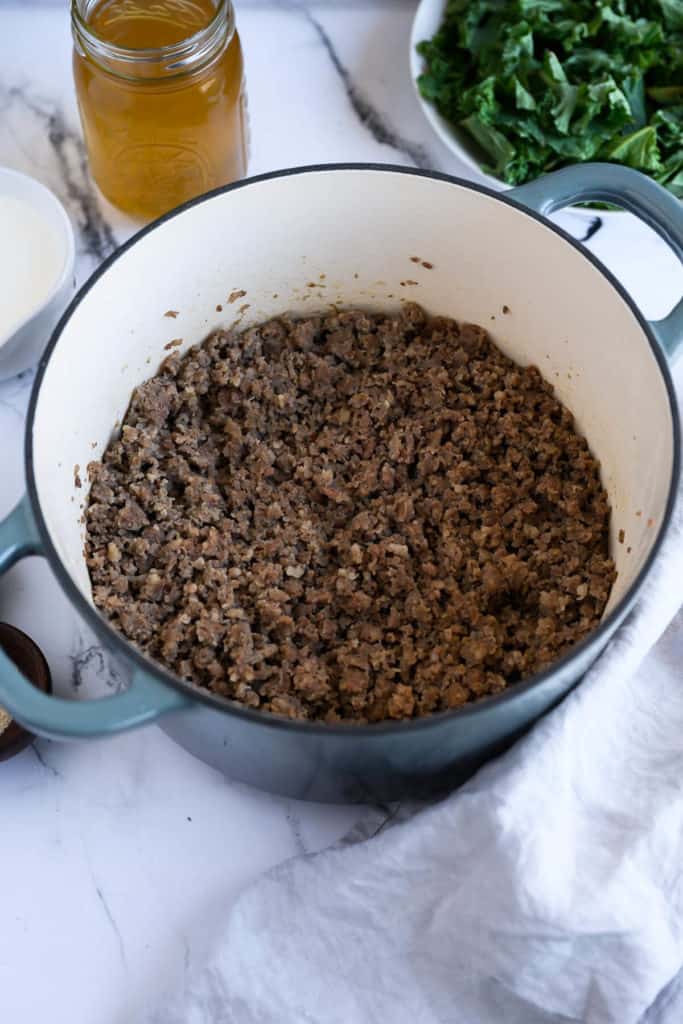 dutch oven of browned pork sausage