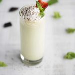 tall glass filled with shamrock shake, garnished with whipped cream, chocolate shavings and a strawberry