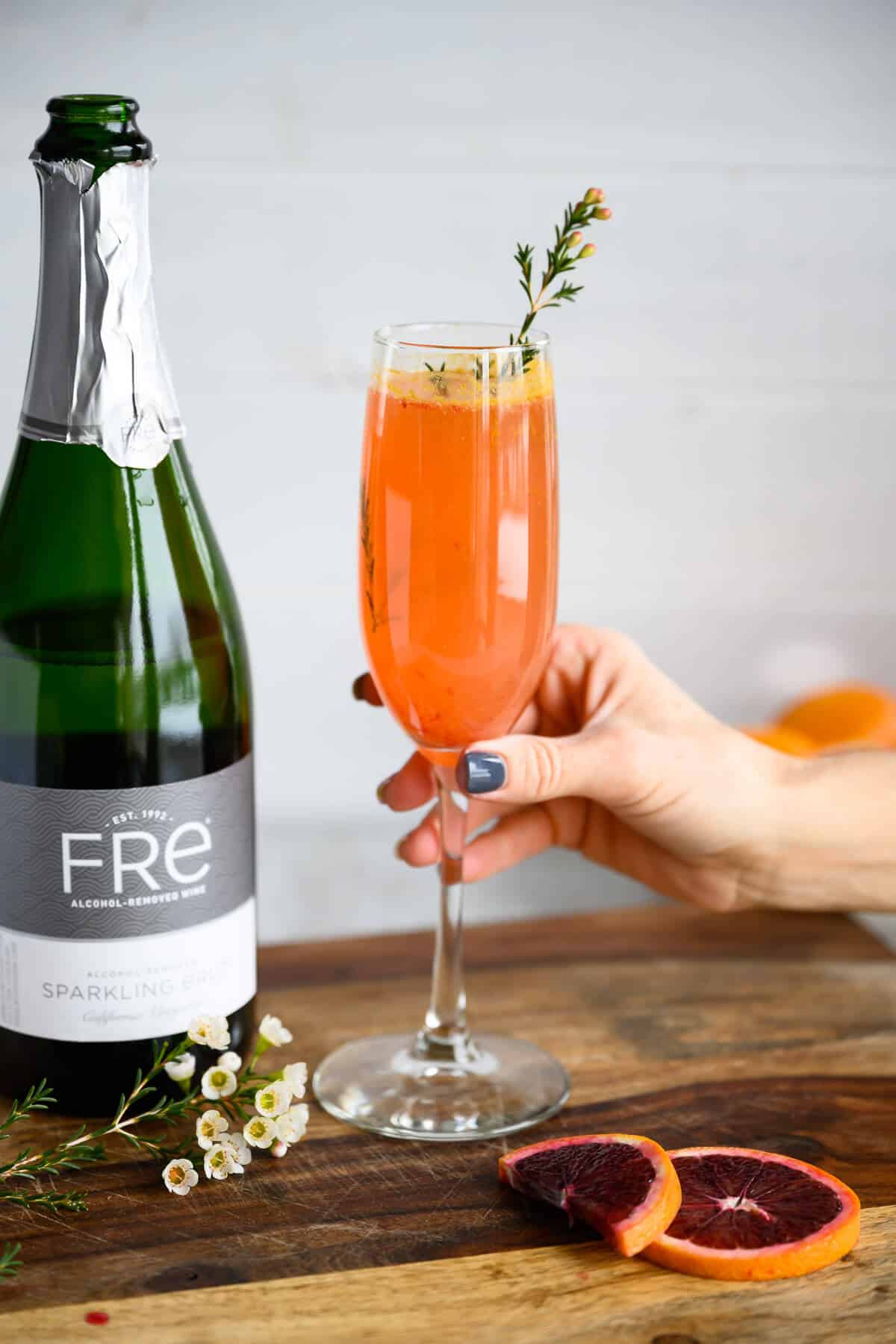 hand grabbing blood orange mimosa mocktail