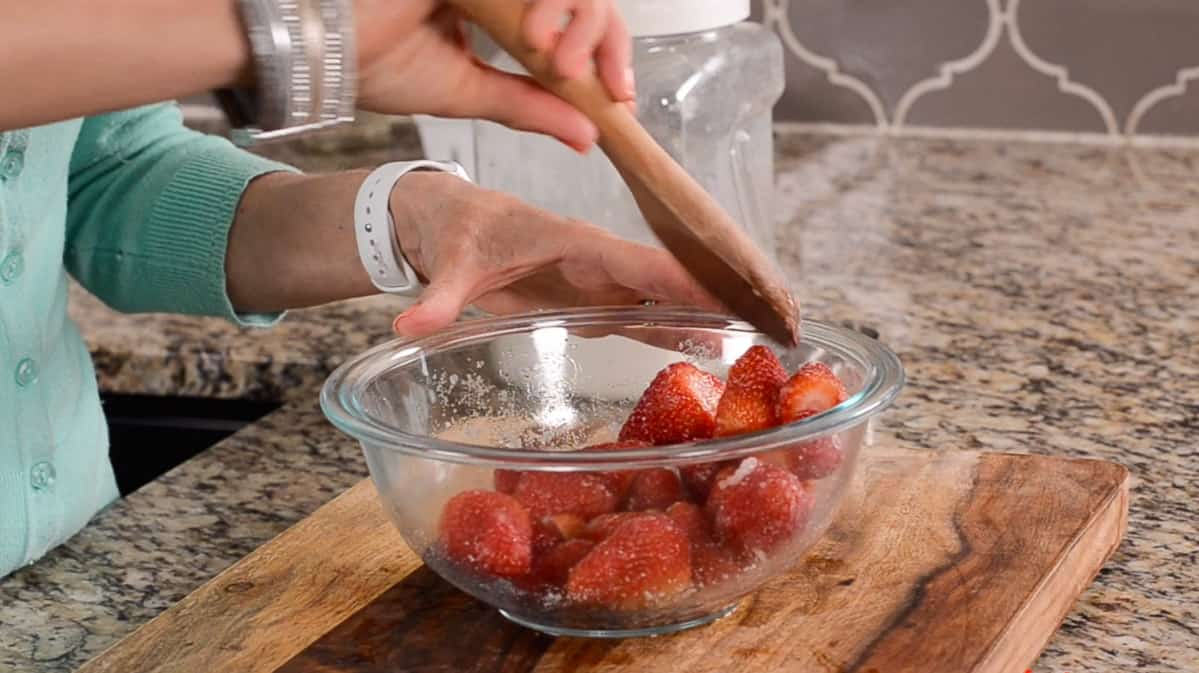 stirring strawberries with sugar on them
