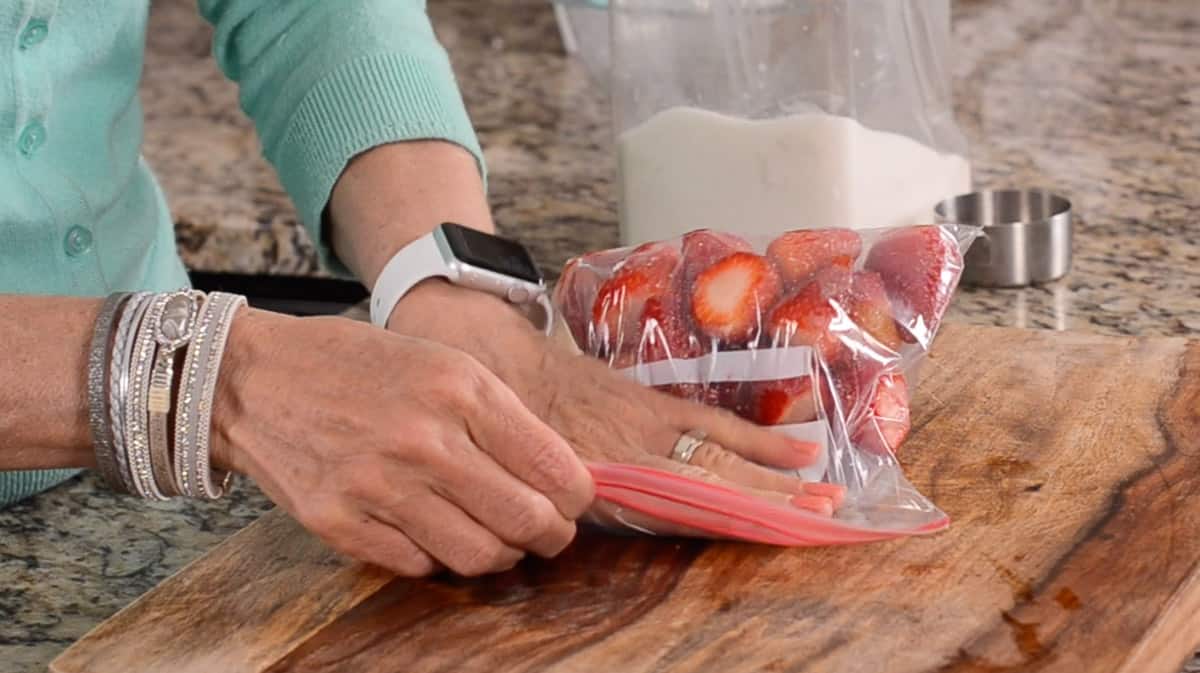 pressing air out of bag of strawberries