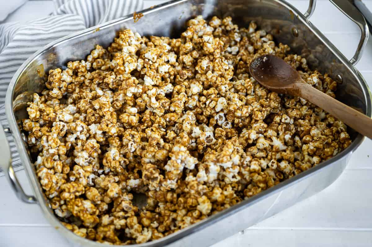 popcorn coated in caramel sauce in a roasting pan prior to cooking