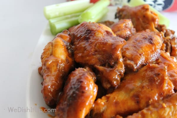 Buffalo chicken wings on a white plate with celery on the side