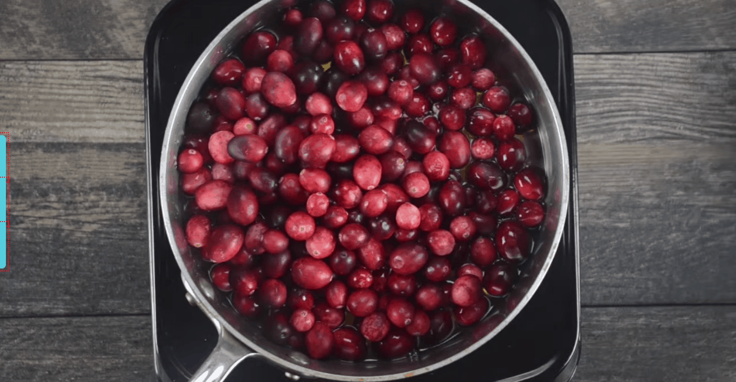 Fresh cranberries with cranberry juice in a pan.