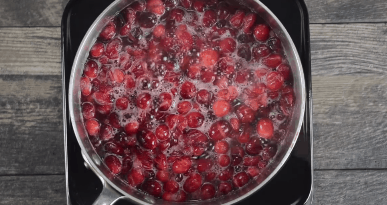 Fresh cranberries simmering in a pan.