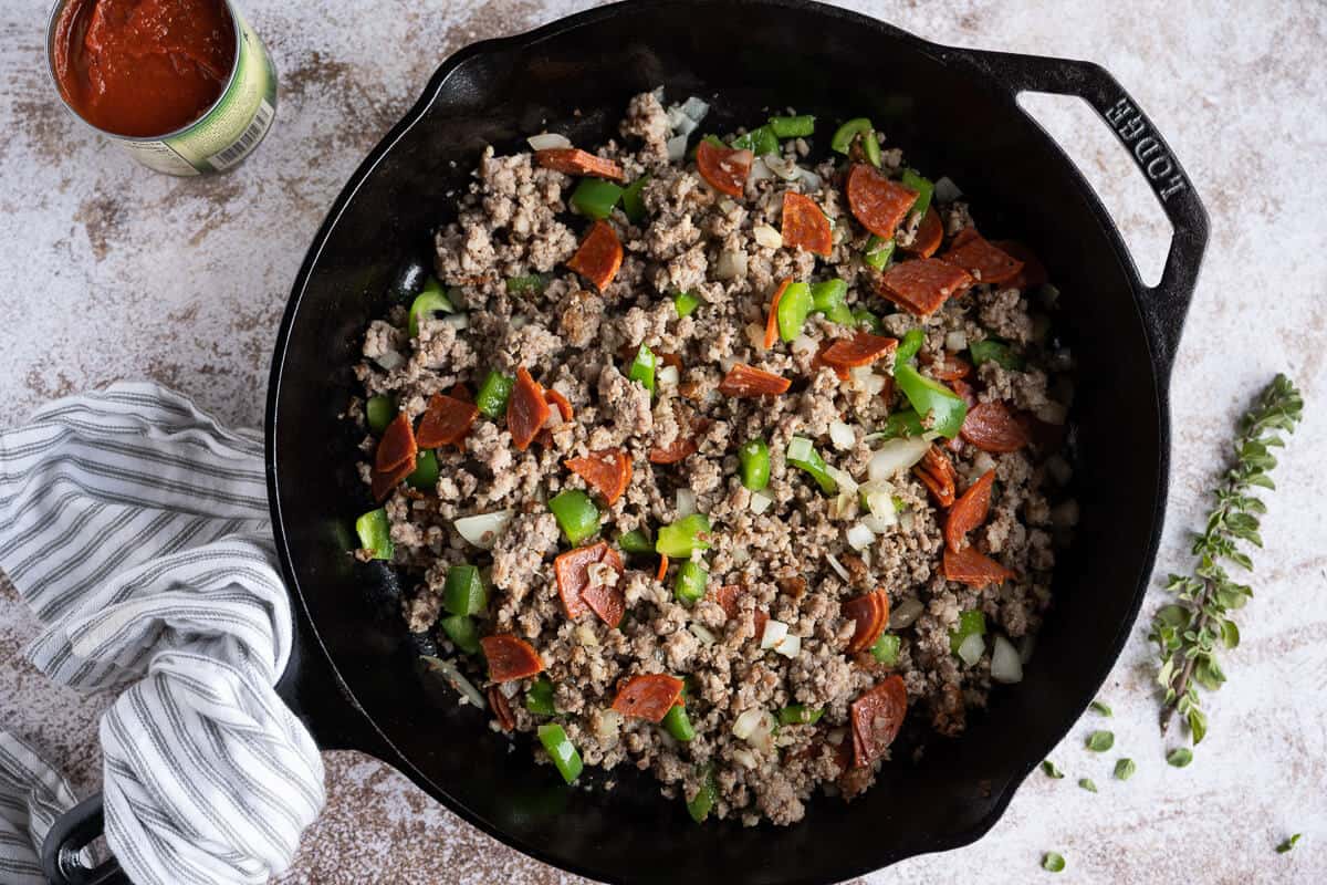 ground sausage, pepperoni, onion and green pepper cooked in a cast iron skillet