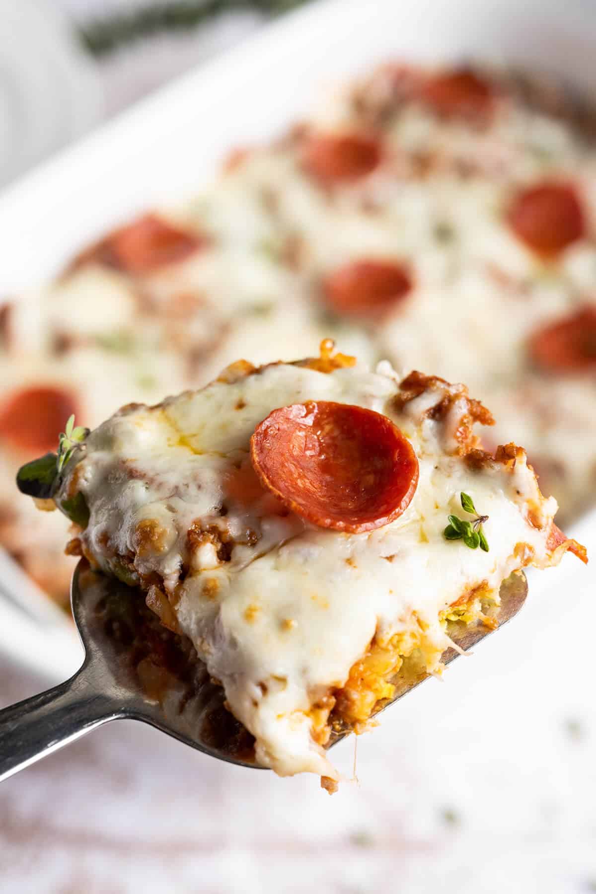 piece of keto pizza casserole on a spatula being served