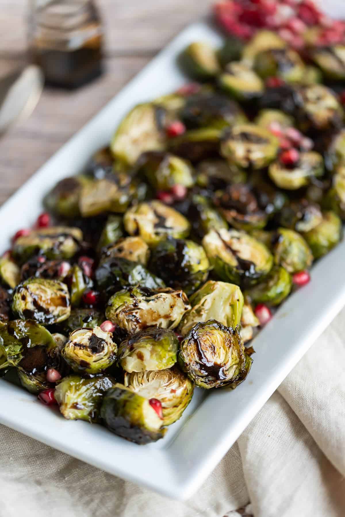 platter of roasted brussels sprouts drizzled with balsamic reduction