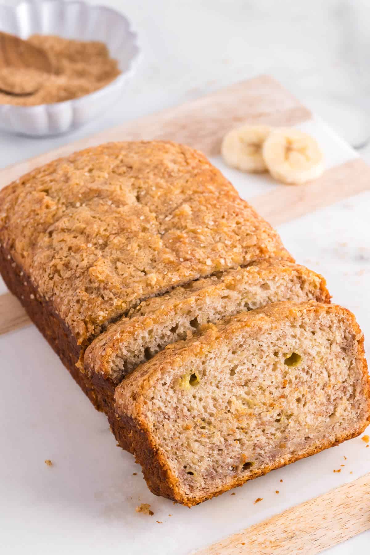 loaf of banana bread with a couple slices sliced off and leaning against the rest of the loaf.