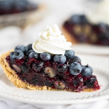 1 slice of fresh blueberry pie topped with homemade whipped cream
