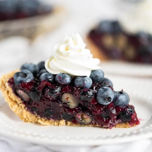 1 slice of fresh blueberry pie topped with homemade whipped cream