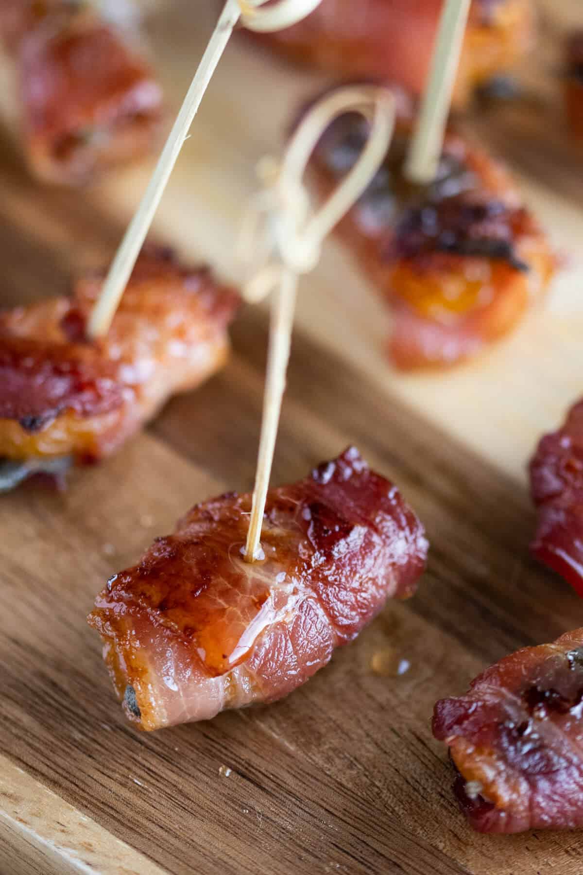 Bacon wrapped apricot with maple syrup dripping down the side.