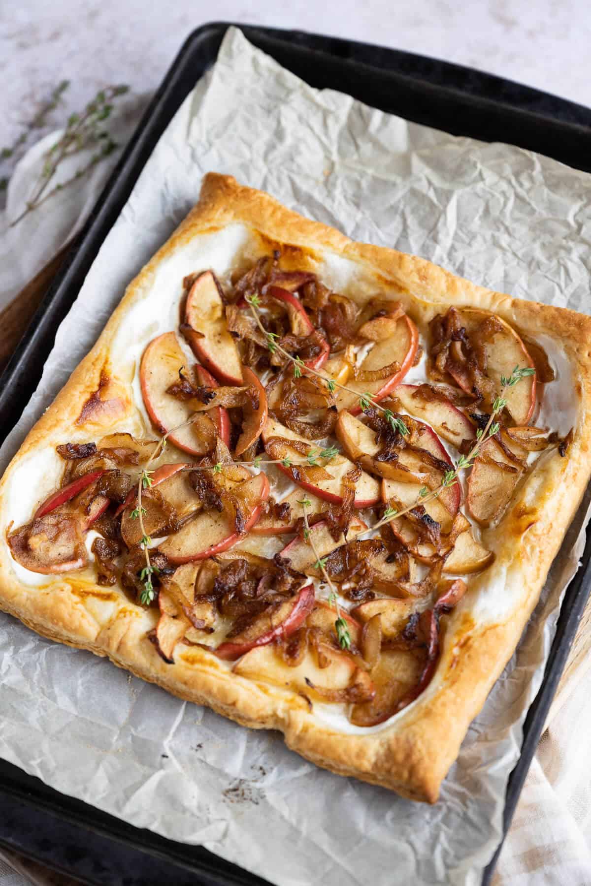 Just baked puff pastry with onions and apples, garnished with fresh thyme.