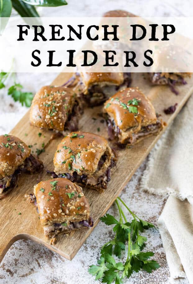 french dip sliders on a wooden serving board, garnished with fresh parsley via @artfrommytable