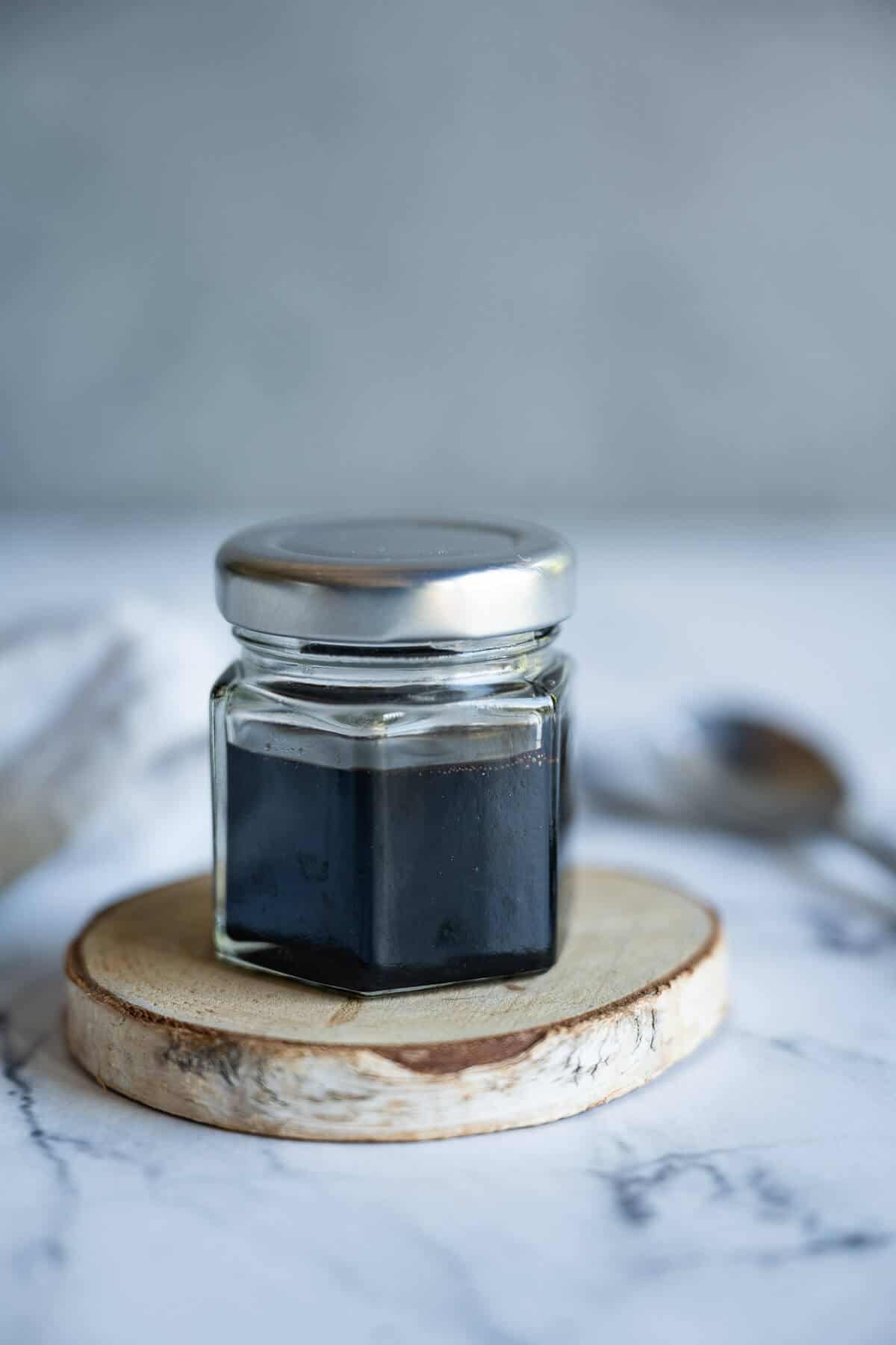 Small glass jar of balsamic reduction sauce.