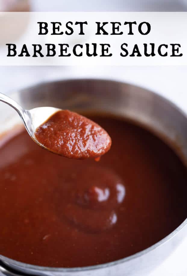 A spoonful of homemade keto barbecue sauce being held up above the pan of simmering sauce. via @artfrommytable