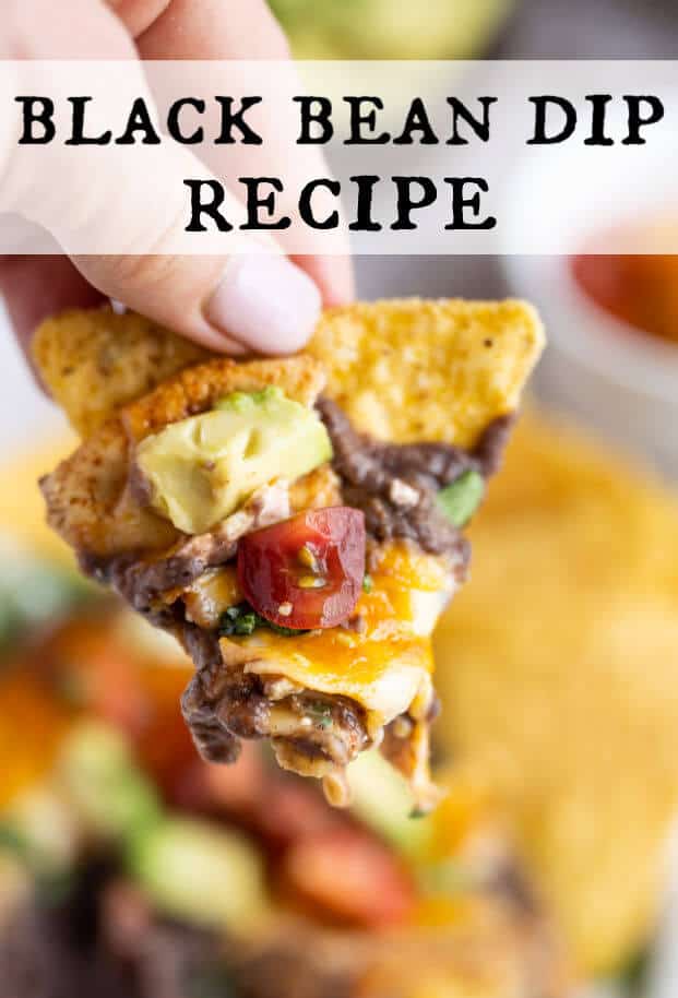 A hand holding a tortilla chip with the black bean dip on it. via @artfrommytable