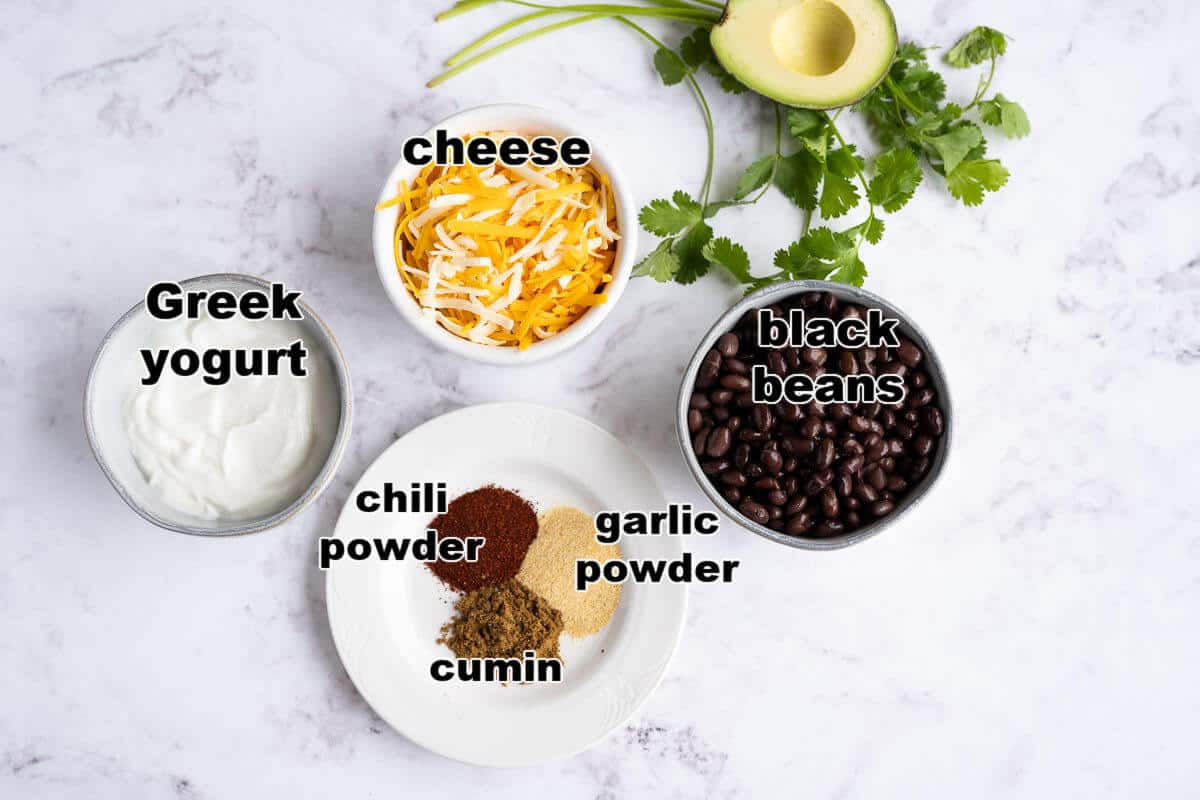 Ingredients to make Black Bean Layered dip: black beans, greek yogurt, shredded cheese, chili powder, garlic powder, and cumin.