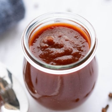 homemade barbecue sauce in a glass jar. Sauce is thick and a reddish brown color.