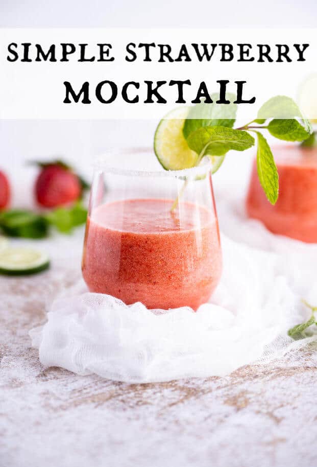 Blended strawberry drink in a stemless wine glass with sugar on the rim. A sprig of fresh mint and a lime slice garnish the drink. via @artfrommytable