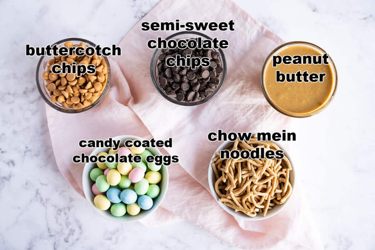 Ingredients to make Bird Nest Dessert: chocolate chips, butterscotch chips, peanut butter, chow mein noodles, and candy chocolate eggs.