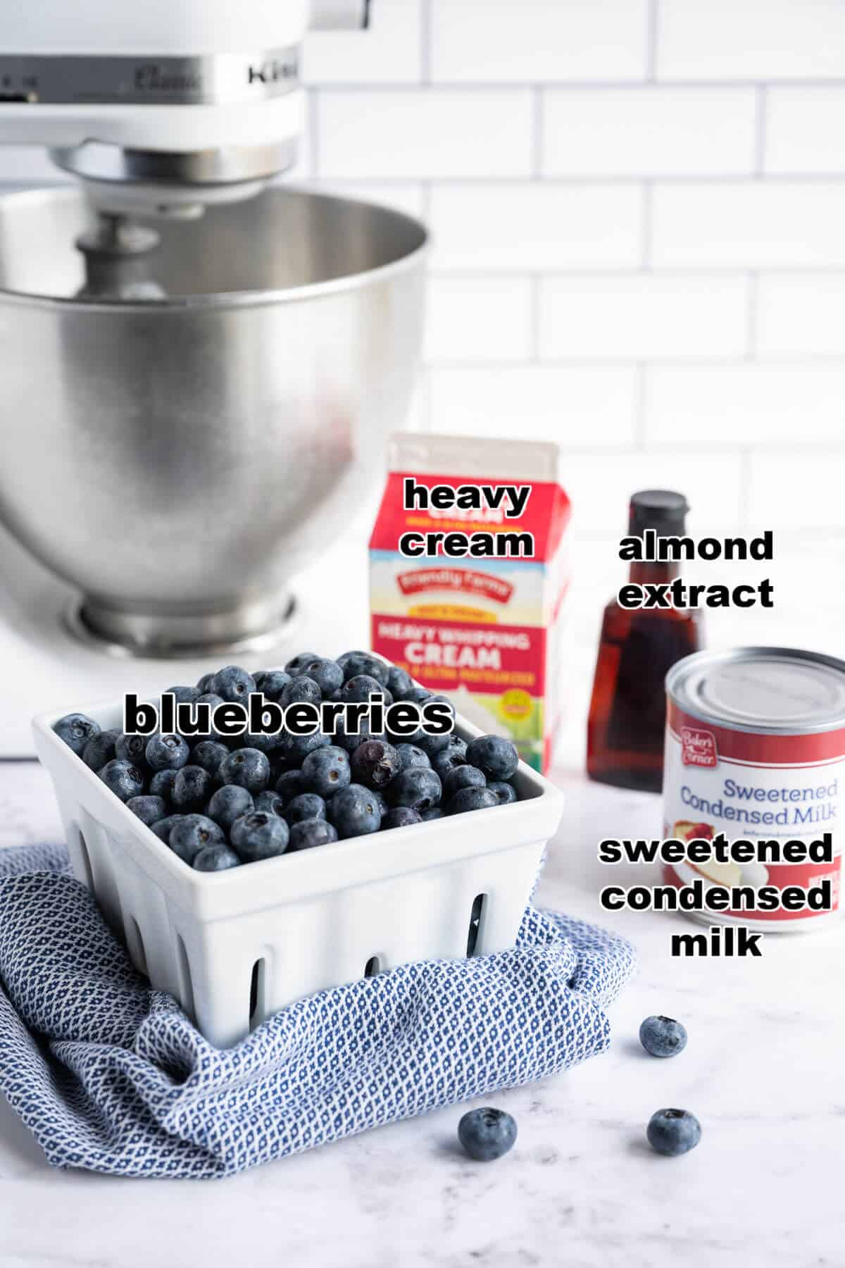 Ingredients for no-churn blueberry ice cream: heavy cream, sweetened condensed milk, blueberries, almond extract.