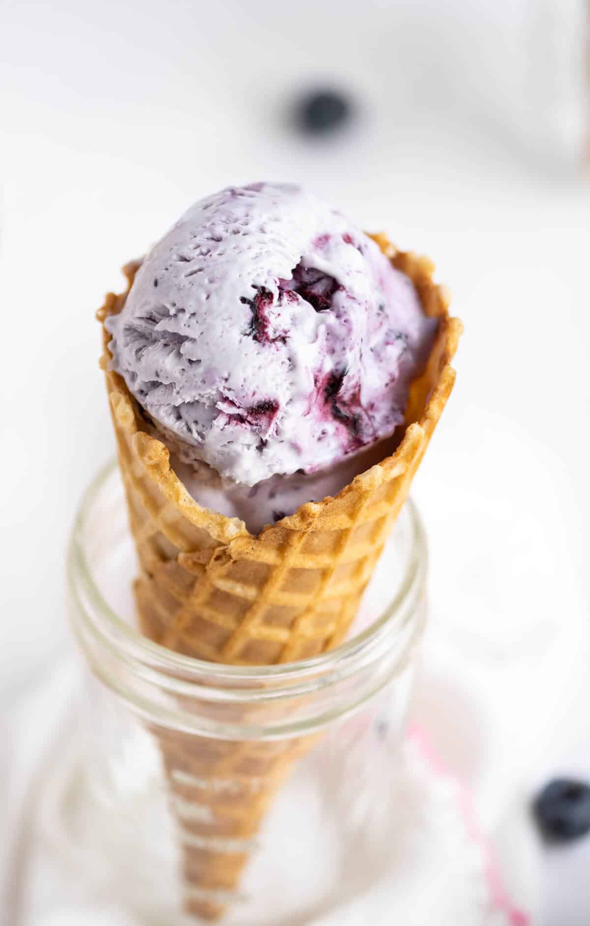 Blueberry ice cream in a waffle cone.