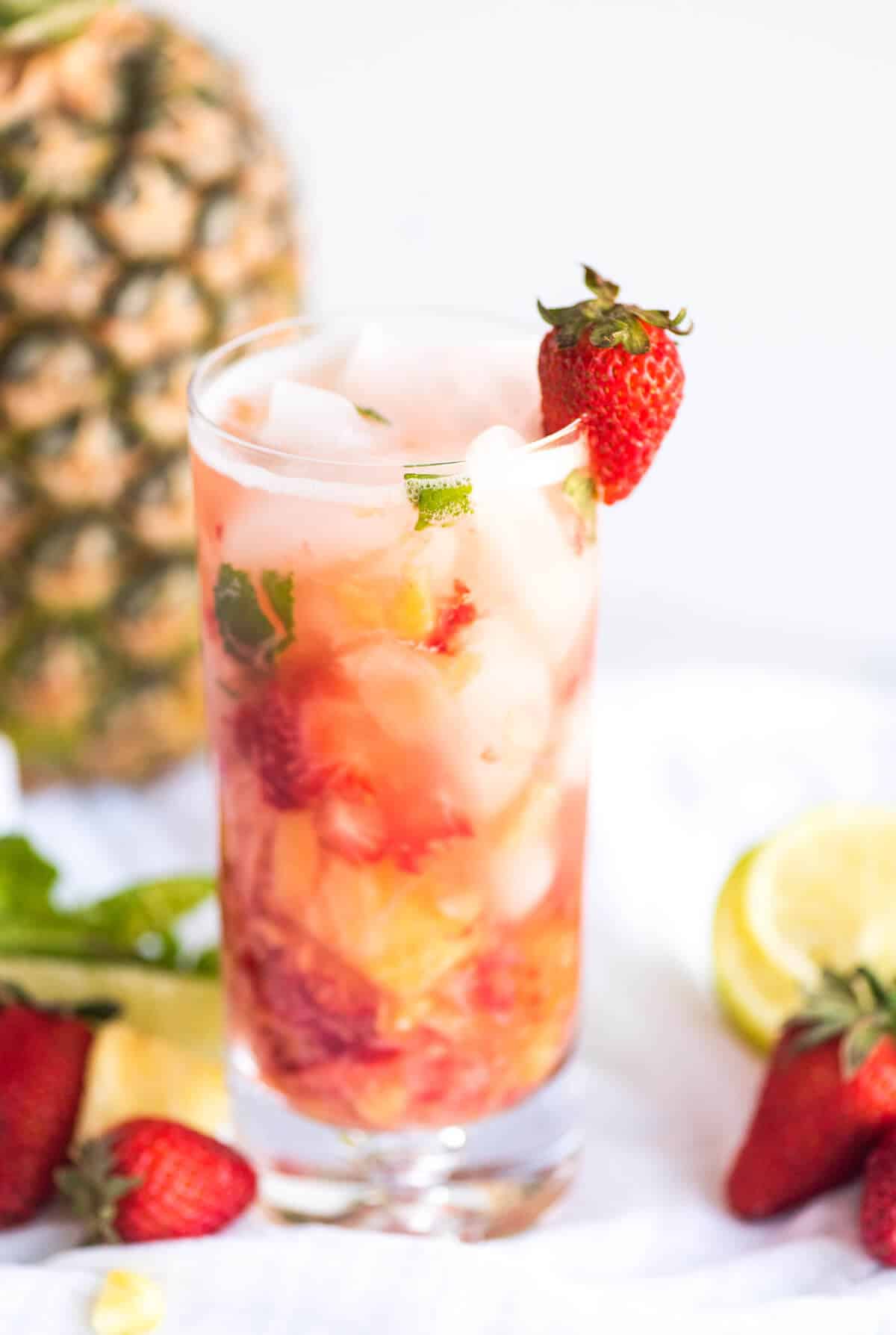 Strawberry Pineapple Mojito Mocktail in a tall glass, garnished with a fresh strawberry.