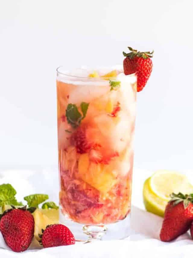 Pineapple Strawberry Mojito in a tall glass with crushed ice.