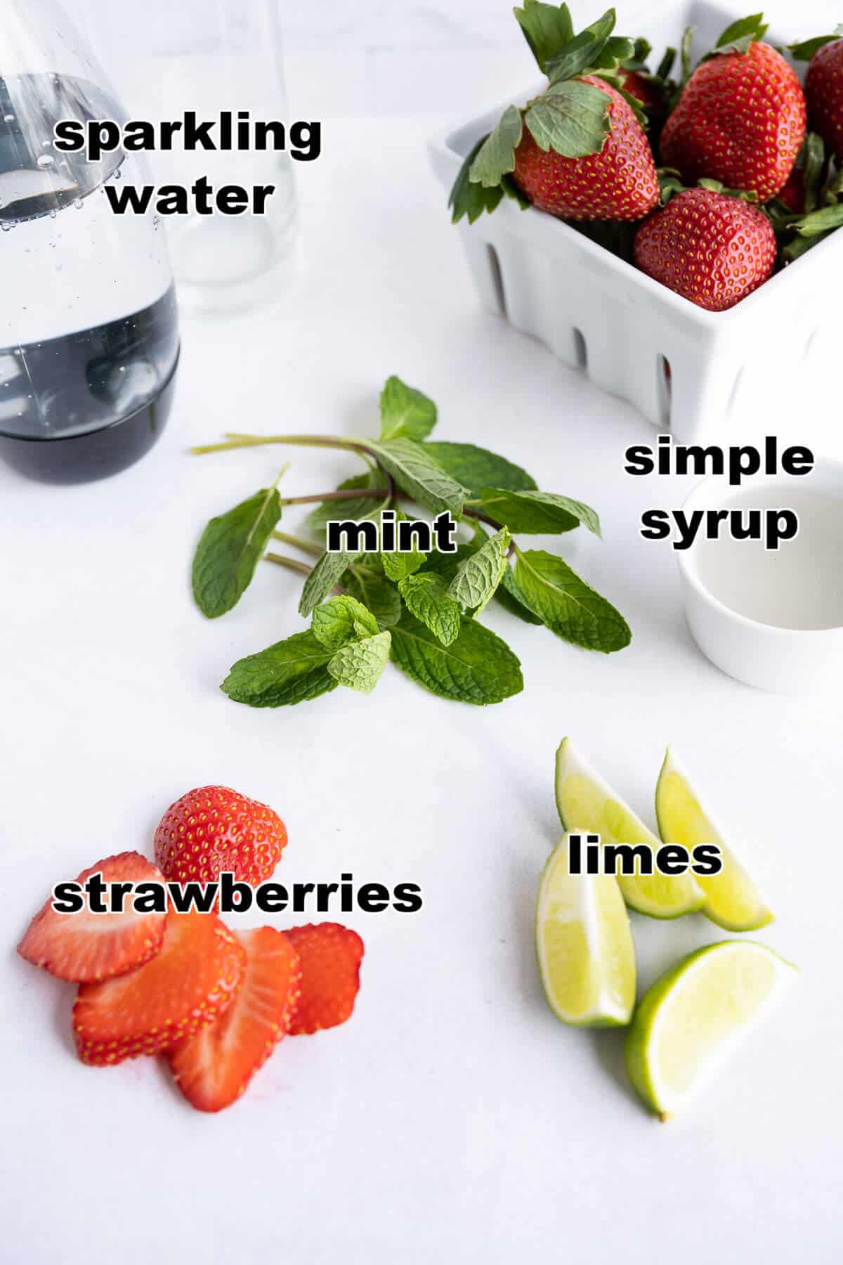 Ingredients for a Virgin Strawberry Mojito: Strawberries, fresh mint leaves, limes, simple syrup and sparkling water.