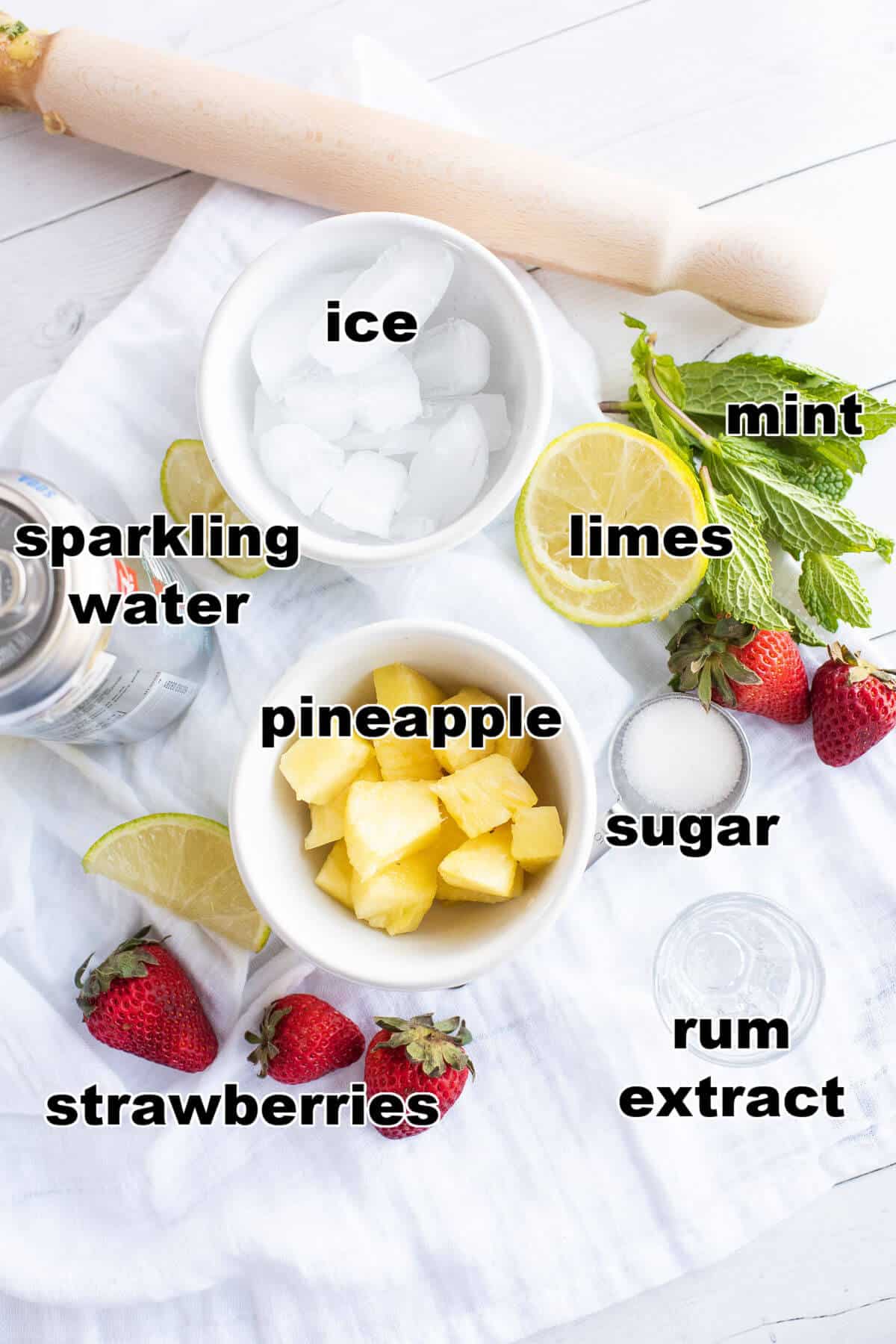 Ingredients for Strawberry Pineapple Mojito Mocktail: ice, sparkling water, pineapple, strawberries, lime, mint, sugar, and rum extract.