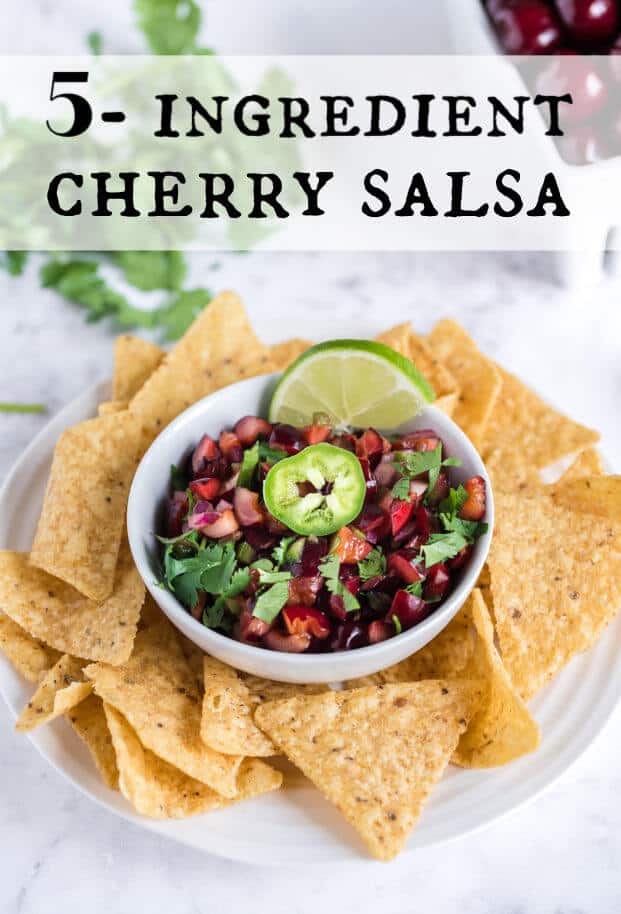A white plate with tortilla chips on it surrounding a white bowl of cherry salsa via @artfrommytable
