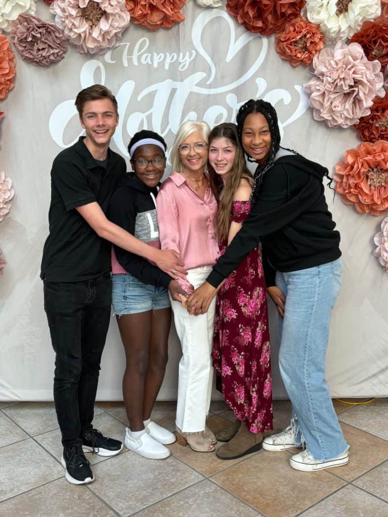 Family in front of a Happy Mother's Day backdrop